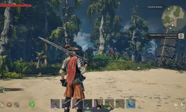 A video game character with a large sword and red cape stands on a sandy beach facing a dense coastal jungle.