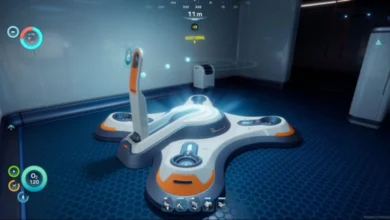 A large, white and orange cross-shaped futuristic device sits on a glowing blue floor inside a high-tech room from a first-person perspective.