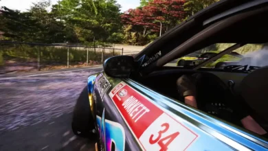 A side-angle view of a sponsored drift car sliding through a scenic, tree-lined curve during a high-speed race.