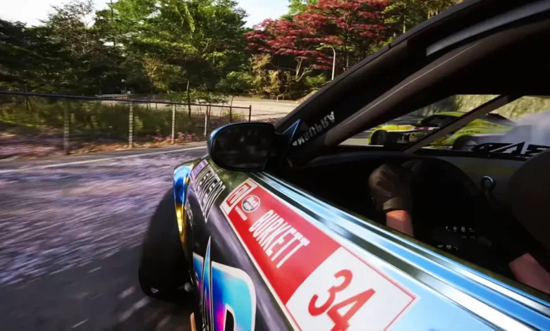A side-angle view of a sponsored drift car sliding through a scenic, tree-lined curve during a high-speed race.