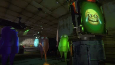 Three small, colorful, armless robot characters stand in a dim workshop looking at a screen displaying a creepy, distorted yellow face.