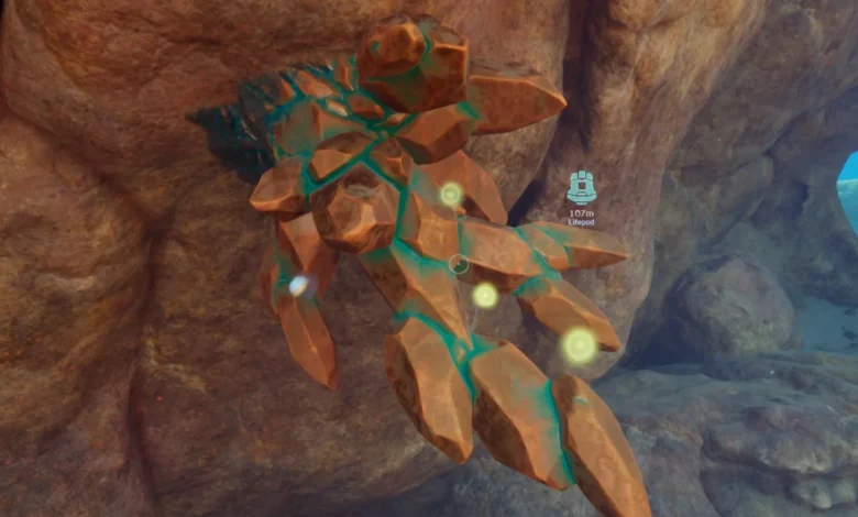 A cluster of amber-colored crystals with glowing teal veins grows from a rocky underwater cave wall in a video game.