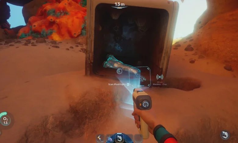 First-person perspective of a player scanning a flashlight fragment inside an open crate on a sandy seabed in an underwater video game.