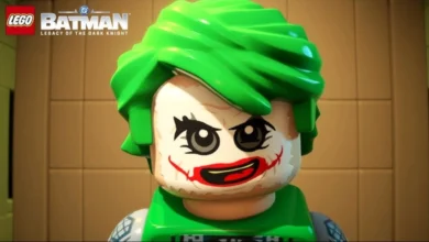 A close-up of a LEGO Joker minifigure with bright green hair and iconic smeared face paint from "LEGO Batman: Legacy of the Dark Knight."
