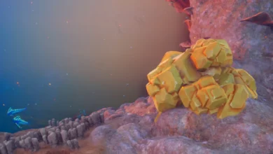 A cluster of golden, faceted crystals sits atop a purple rock shelf in a hazy, alien-like underwater environment.