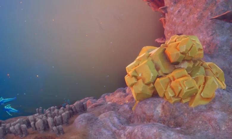 A cluster of golden, faceted crystals sits atop a purple rock shelf in a hazy, alien-like underwater environment.