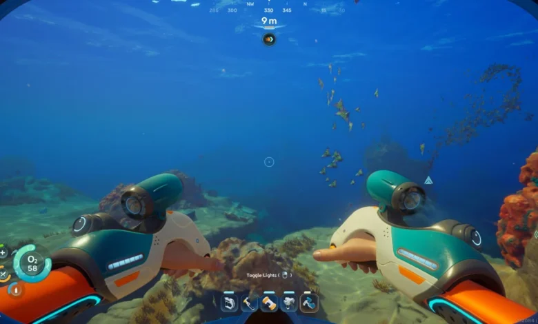 First-person perspective from an underwater video game showing a character holding futuristic exploration tools while swimming through a deep blue ocean with coral reefs.