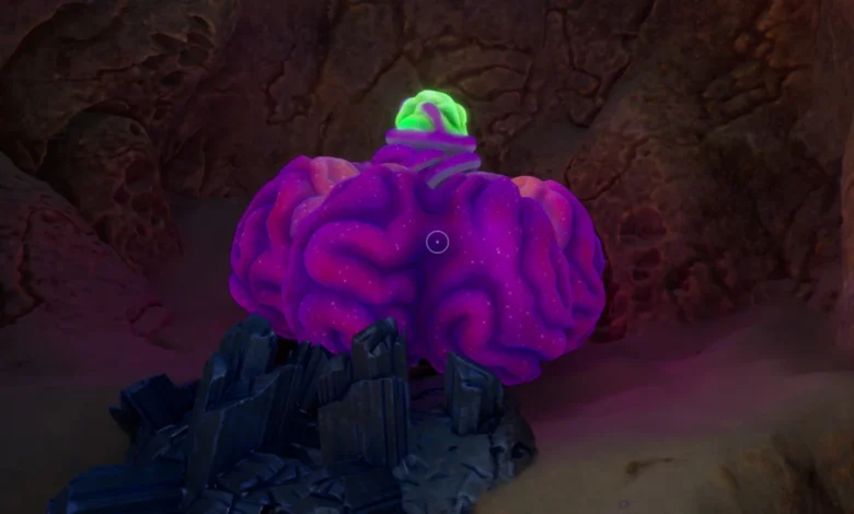 A large, purple brain-like growth with a glowing green topper sits on dark crystals inside a dimly lit rocky cave.