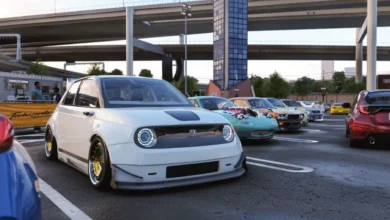 A modified white Honda e electric car is parked at an outdoor car meet beneath urban highway overpasses.