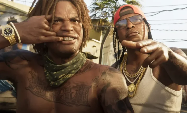 Two tattooed men with gold jewelry and grills pose confidently in a sun-drenched outdoor urban setting from the Grand Theft Auto VI trailer.