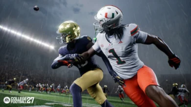 A Miami Hurricanes player and a Notre Dame player compete for a football in the rain during a night game in EA Sports College Football 25.