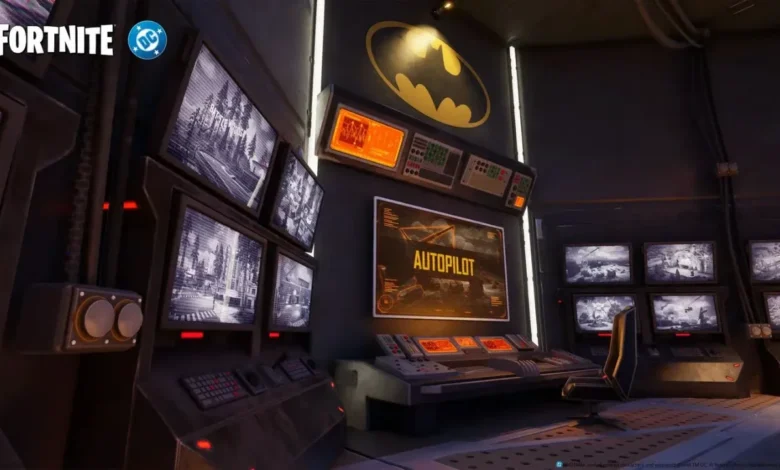 A high-tech Batcave command center in Fortnite featuring multiple surveillance monitors and a large yellow Batman logo on the wall.