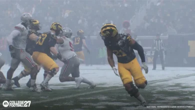 Michigan and Ohio State football players compete on a snow-covered field in a scene from the EA Sports College Football video game.