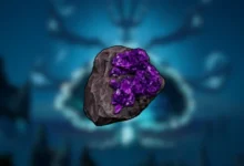 A dark grey rock embedded with vibrant purple crystals, centered against a blurred, glowing blue background.