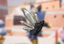 A cluster of pointed, translucent gray crystals growing from a dark rock base against a blurred anime-style background.
