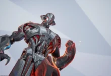 Low-angle shot of the metallic Marvel villain Ultron with silver robotic armor and glowing red internal lights against a minimalist grey background.
